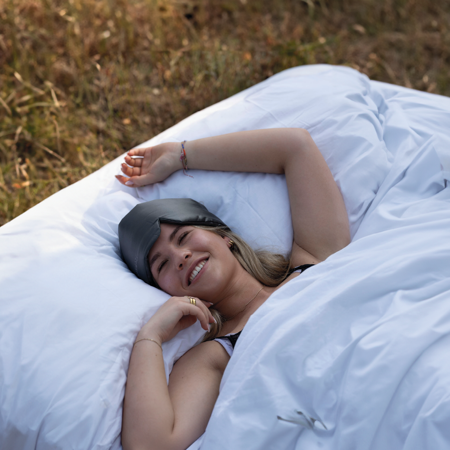 Zijden slaapmasker van DreamEaze op een zacht bed